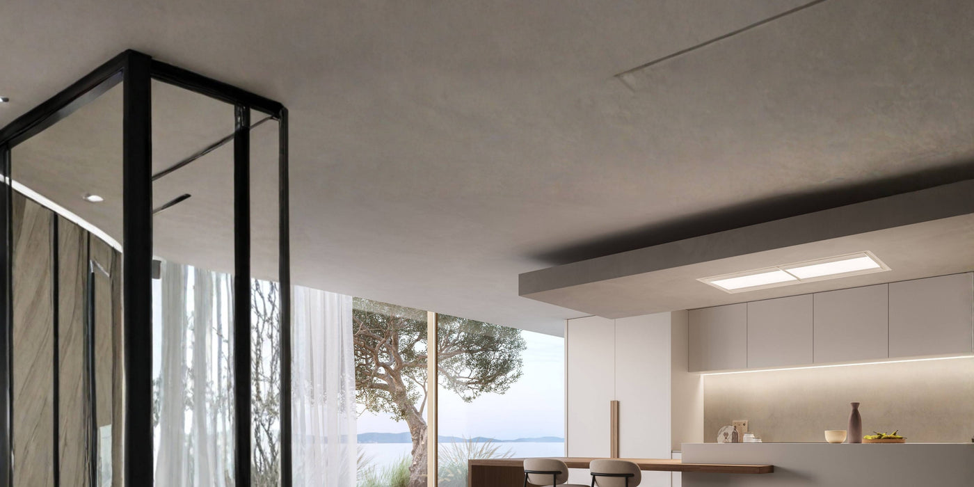 Moderne Küche mit einer Kücheninsel über der ein, flachbündig verbeuter, Deckenlüfter in der der Decke montiertist.