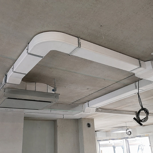 Platzsparende Verlegung von weißen Flachkanälen in der abgehängten Decke für einen Deckenlüfter.